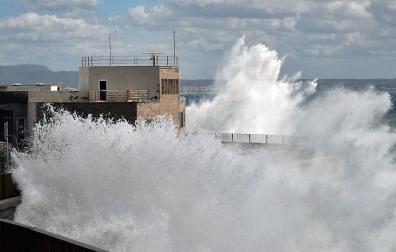 Las olas rompen en el dique del oeste y pasan por encima de la escuela naútica, este miércoles en Palma de Mallorca