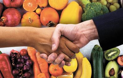Dos personas estrechan la mano tras alcanzar un acuerdo en un supermercado./