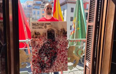 Ángel Blanco posa en el balcón del Ayuntamiento de Pamplona con su obra *Gaiteros", el cartel ganador que anunciará los Sanfermines 2024