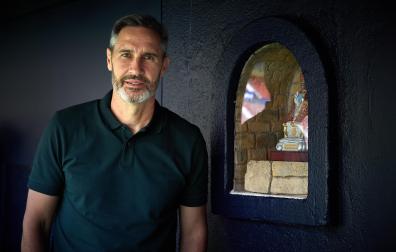 Tras atender a los medios, el entrenador valenciano posó en la banda junto a la hornacina de San Fermín.	urdíroz