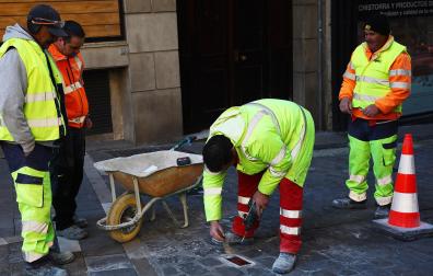 Varios operarios colocan una de las placas en recuerdo de los fallecidos en el encierro el pasado mes de diciembre