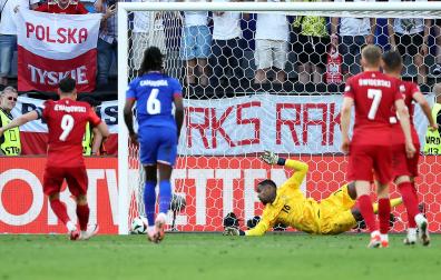 El meta galo Mike Maignan no puede detener el penalti de Robert Lewandowski que puso el empate en el marcador