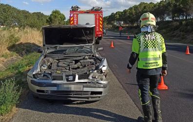 Un bombero, junto al turismo implicado en el accidente
