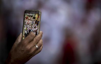 Una persona capta un instante de un encierro de Sanfermines a través de un teléfono móvil