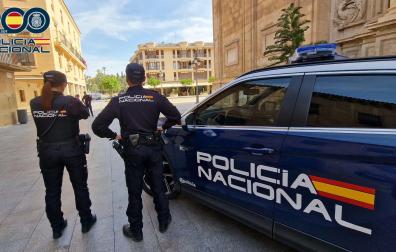 Imagen de agentes y un coche patrulla de la Policía Nacional