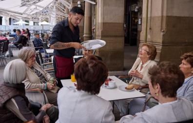 Un camerero le sirve a unas señoras en el Café Iruña