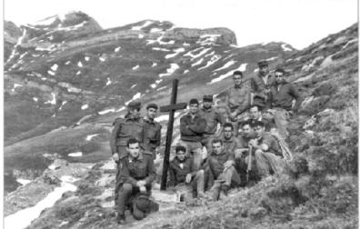 Un grupo de supervivientes, junto a la cruz en memoria de los fallecidos, en el Orhi