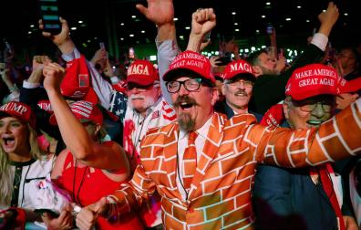 Seguidores de Donald Trump celebran la victoria del expresidente durante la noche electoral, uno de ellos viste un traje alusivo al muro que empezó a construir en la frontera.