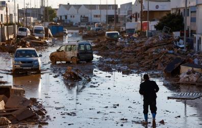 Una persona camina por una calle del polígono de Catarroja, este lunes, donde todavía se pueden ver los efectos de la DANA y las devastadoras inundaciones sin limpiar