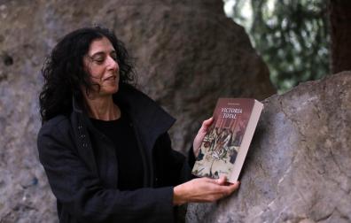 Begoña Pro, contemplando la portada de la novela 'Victoria total', publicada por Mintzoa