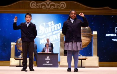 Los niños de la Residencia San Ildefonso de Madrid Ainhoa Rosero (d) y Axiel Kyron (i) muestran el número 11.840, un tercer premio