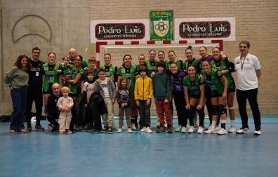 La plantilla del Replasa Beti Onak posando con algunos de los menores realojados en Villava al final del encuentro