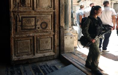 Una agente de la policía fronteriza israelí vigila la entrada de la Iglesia del Santo Sepulcro en la Ciudad Vieja de Jerusalén