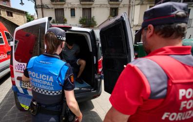 Dos agentes de la Policía Municipal de Pamplona y de la Policía Foral junto a uno de los detenidos