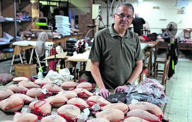 Héctor Pérez, gerente de Las Tres ZZZ, en la fábrica taller, junto a las botas que reciben para su puesta a punto
