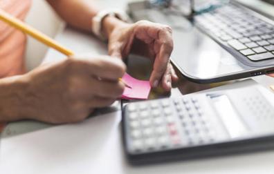 Imagen de una persona manejando documentación y una calculadora