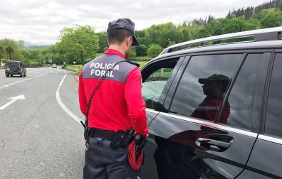 Un agente de la Policía Foral charla con el conductor de un coche, detenido en el arcén