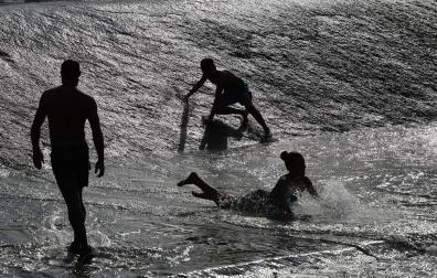 Bañistas en el río Arga, una forma de combatir los más de 40 grados que se han alcanzado hoy en Pamplona.