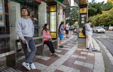 Varias personas esperan la villavesa, en una parada en el límite entre Pamplona y Barañáin, este 17 de septiembre a las 8 de la mañana.