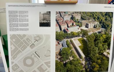 Panel con el proyecto ganador del concurso que muestra una imagen aérea del edificio