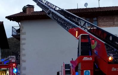 Bomberos de Navarra trabajan en la cubierta de la vivienda afectada por las llamas /