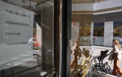 Cartel que indica el cierre temporal en la fachada principal de la clínica dental de Alzira.