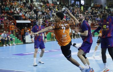 El pivote estellés Abib Diop se dispone a lanzar desde el pivote tras superar la defensa del zizurtarra Antonio Bazán, pivote navarro del Barça