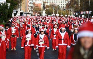 Participantes de todas las edades recorren el centro de Madrid vestidos de papá noeles durante la 14ª edición de la Carrera de Papá Noel