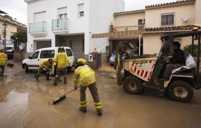 Labores de limpieza de las calles este domingo en Estación de Cártama después de los problemas sufridos anoche en la localidad por la crecida del río Guadalhorce