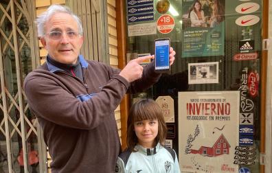 El dueño delante de la tienda deportes donde expendio de máquina el décimo premiado con el gordondel Niño , Serafín García Segura y su sobrina Vega García Sainz