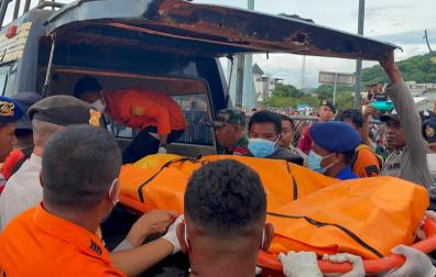 Los equipos de rescaten introducen en un vehículo los restos del cuerpo sin vida del niño recuperado de las aguas