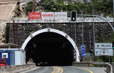 Vehículos circulando por el túnel de Belate, el pasado 18 de junio. A la izquierda, la boca sur de Belate esta semana, sin el cartel de Servinabar. Arriba, una imagen del verano, con los tres logos.