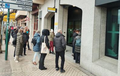 Varias personas esperan ante las puertas de la oficina de la Seguridad Social en Pamplona