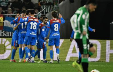 Los jugadores colchoneros celebran uno de los tantos ante la desolación del bético Chimy Ávila