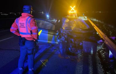 Un agente de Tráfico de la Policía Foral observa el estado en el que quedó el vehículo de la joven