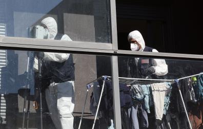 Efectivos de la Policía Científica de Policía Foral, en el piso en el que se produjo el asesinato de una mujer a manos de su marido en Sarriguren