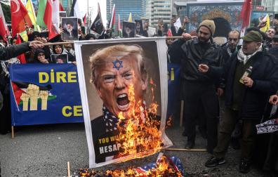 Manifestantes queman una pancarta con el rostro del presidente estadounidense Donald Trump, en una protesta contra los ataques en Estambul
