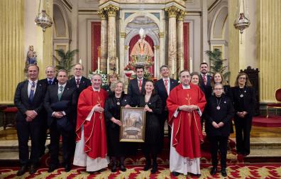La priora Marimar Ganuza y Neus Vives sostienen el lienzo que regaló la parroquia a las Hermanas de la Soledad, el puente entre San Fermín y la Dolorosa. Con ellas, el párroco de San Lorenzo, Javier Leoz; Juan Luis Lorda, capellán de la Hermandad de la Pasión y la junta de la institución.