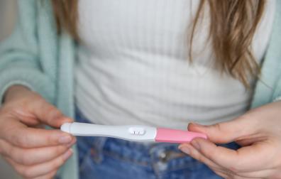 Una mujer sostiene un test de embarazo