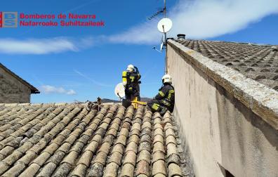 Dos bomberos trabajando en el tejado de la vivienda afectada por un incendio en San Martín de Unx