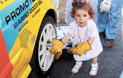 Marina, de pequeña, emulando un cambio de ruedas en el coche