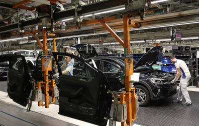 Operarios del taller de montaje en la fase de colocación de las puertas de uno de los coches