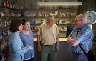 Desde la izda., la farmacéutica de Ezcároz Pepa Vicente Collado, y los clientes Rosa Anaut Petroch, Jaime Eseberri Barber y Alejandro Torrea, comentando la noticia de la visita de un oso al pueblo