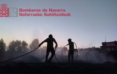 Dos bomberos trabajan en el incendio que ha afectado a un talud cerca del casco urbano de Lerin