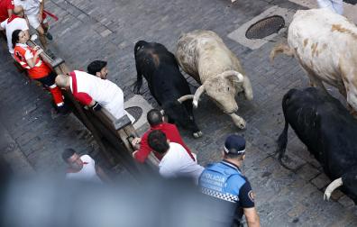 Fotos del primer encierro de San Fermín a su paso por la plaza del Ayuntamiento.
