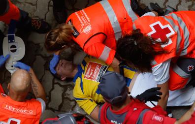 Un mozo es atendido por los servicios sanitarios tras participar en el sexto encierro de San Fermín