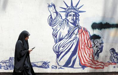 Una mujer pasa delante de una pintada antinorteamericana en el edificio donde estuvo la embajada de EE UU en Teherán