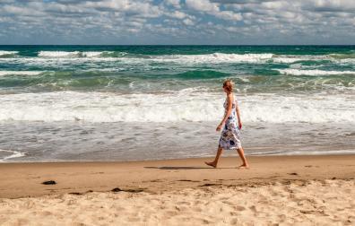 Una mujer da un paseo por la playa