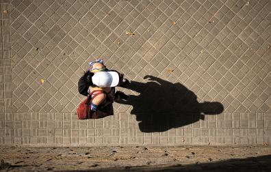 Una persona camina bajo el sol durante la ola de calor de junio