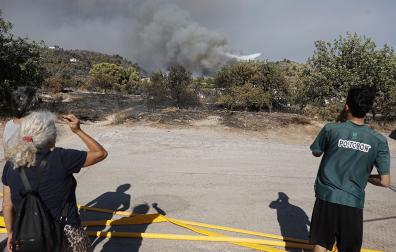 Varias personas observan la pelea contra las llamas en el incendio de La Vall d'Uixò (Castellón)